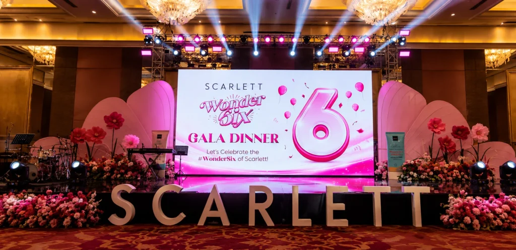 Stage gala dinner Scarlett Wonder Six dengan LED screen, lighting event, dekorasi bunga premium, dan setup ballroom mewah untuk corporate event di Jakarta oleh Sakata Global Indonesia.